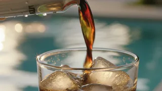 Cold brew pouring into a tumbler of ice